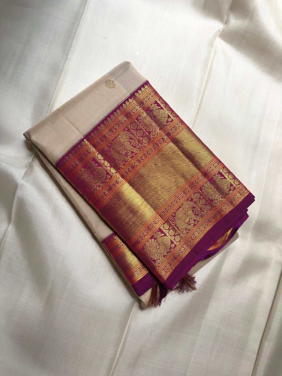 Ivory Kanchipuram silk saree with broad amethyst purple border and antique gold zari
