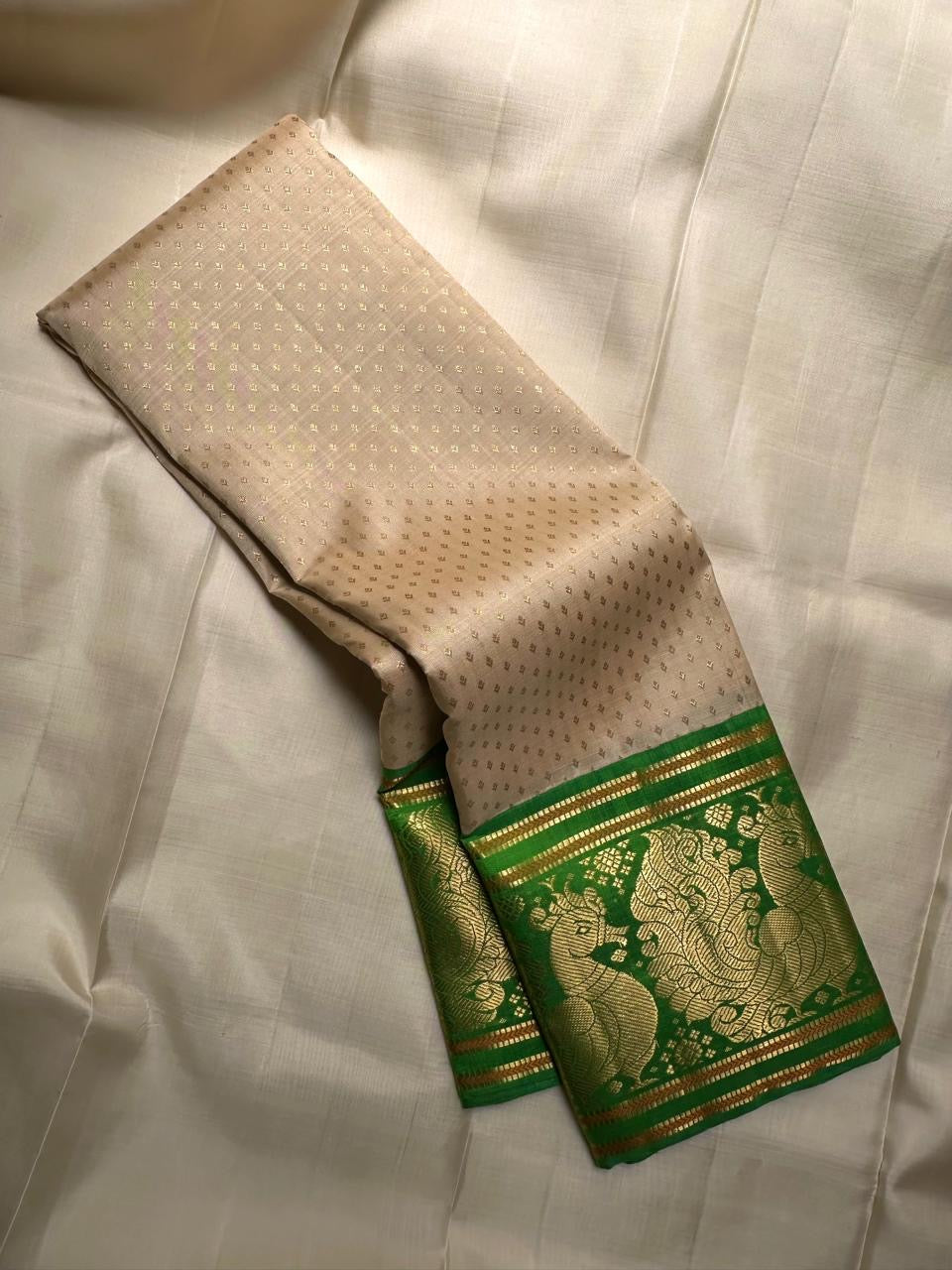 Close-up of gold zari buttas on soft ivory Kanjipuram silk saree body