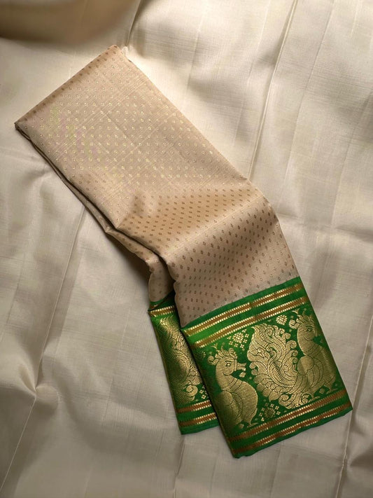 Close-up of gold zari buttas on soft ivory Kanjipuram silk saree body