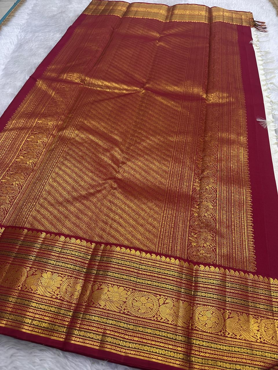 Arakku red border and richly worked pallu of an ivory Pure Silk Kanchipuram saree.
