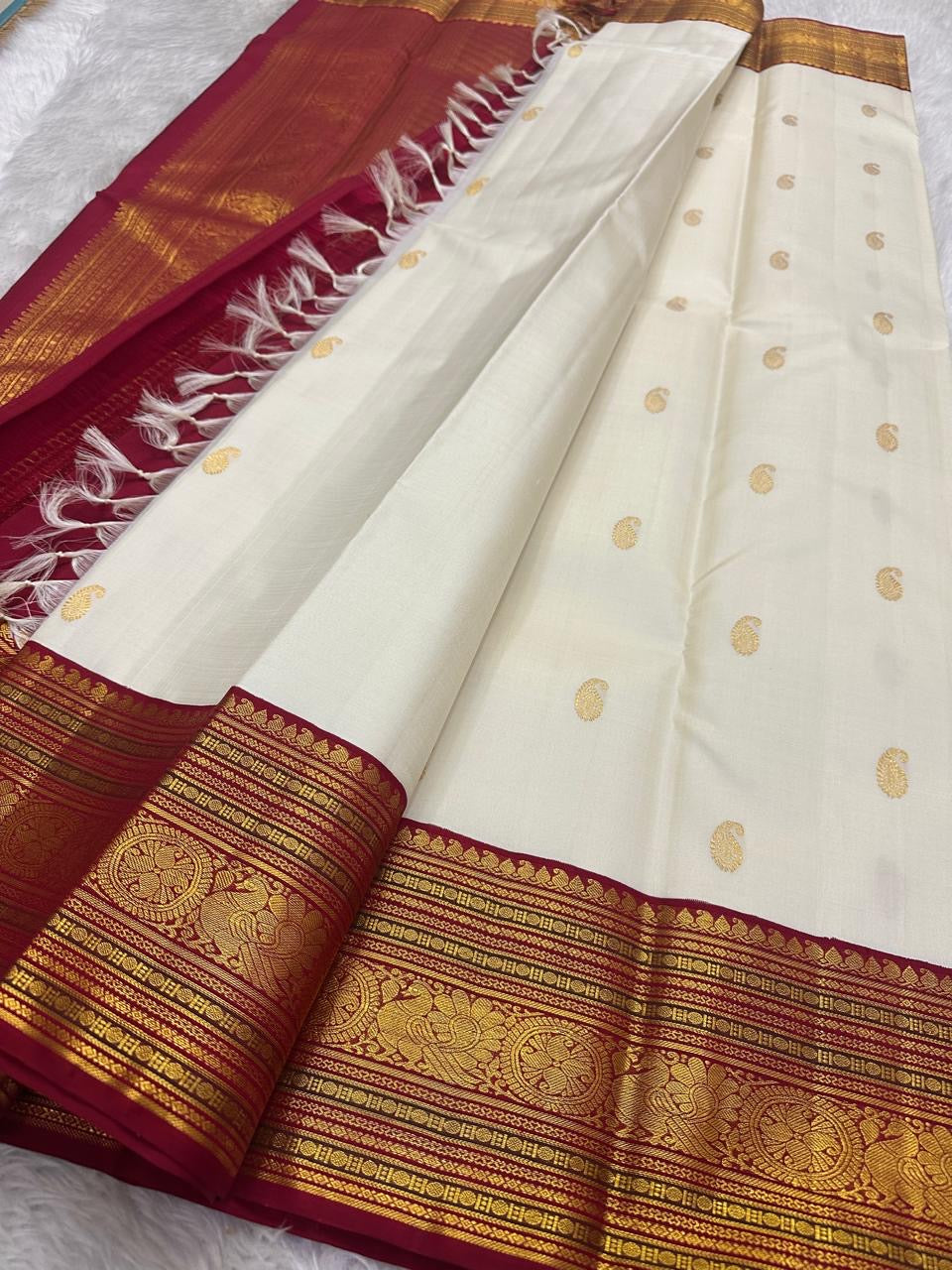 Ivory Pure Silk Kanchipuram Varisaipet saree with petite gold maanga buttas and an Arakku red border.