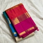 Folded ivory Kanchipuram silk saree with zari woven buttas and hot pink border over teal-blue layer.