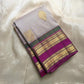 Folded pearl silver pure Kanchipuram silk saree with gold paisley buttas and magenta zari woven border