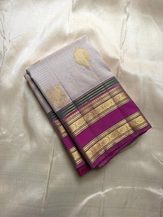 Folded pearl silver pure Kanchipuram silk saree with gold paisley buttas and magenta zari woven border