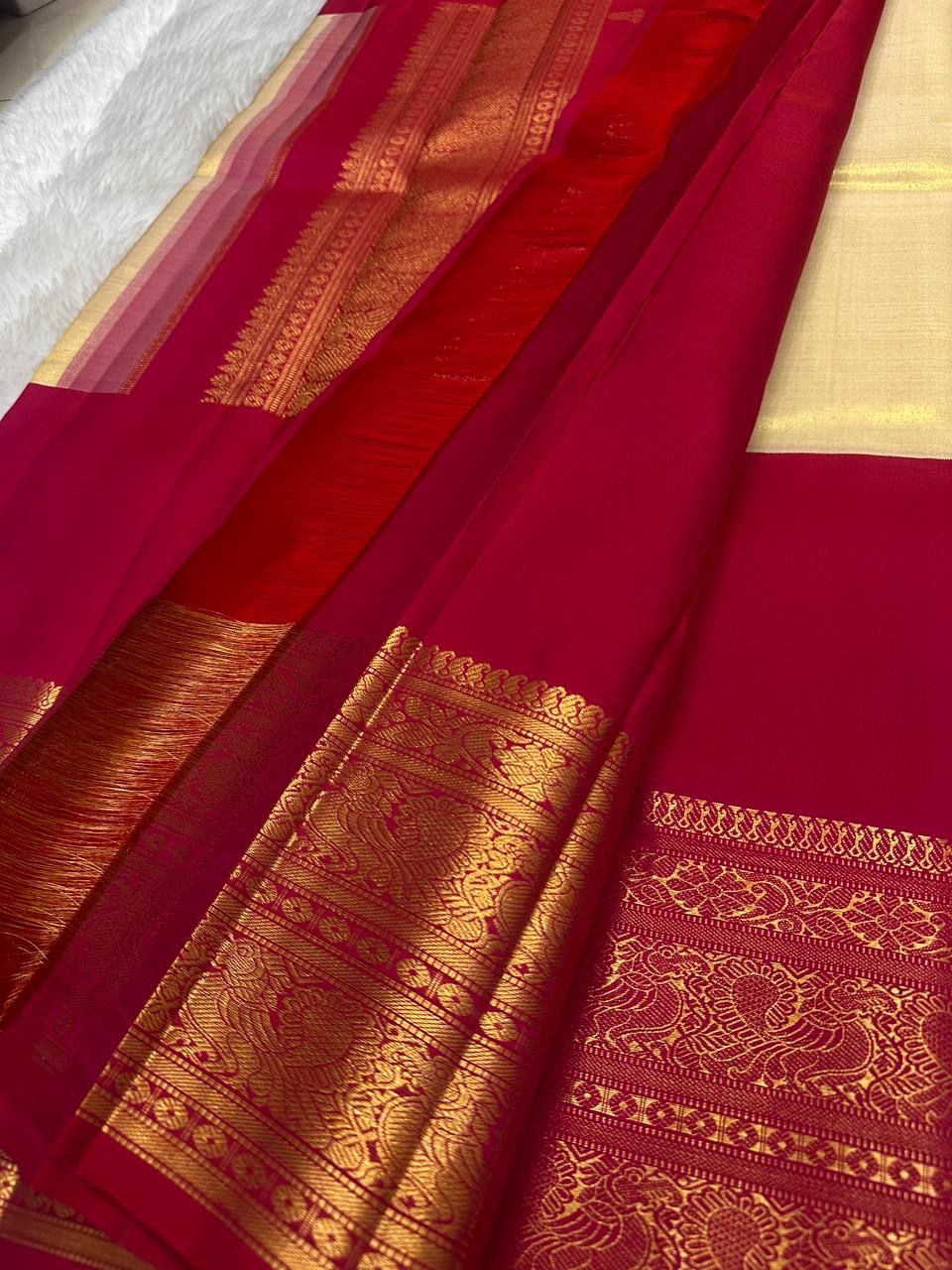 Soft ivory KanchiPattu saree — antique-gold zari peacock border motif close-up