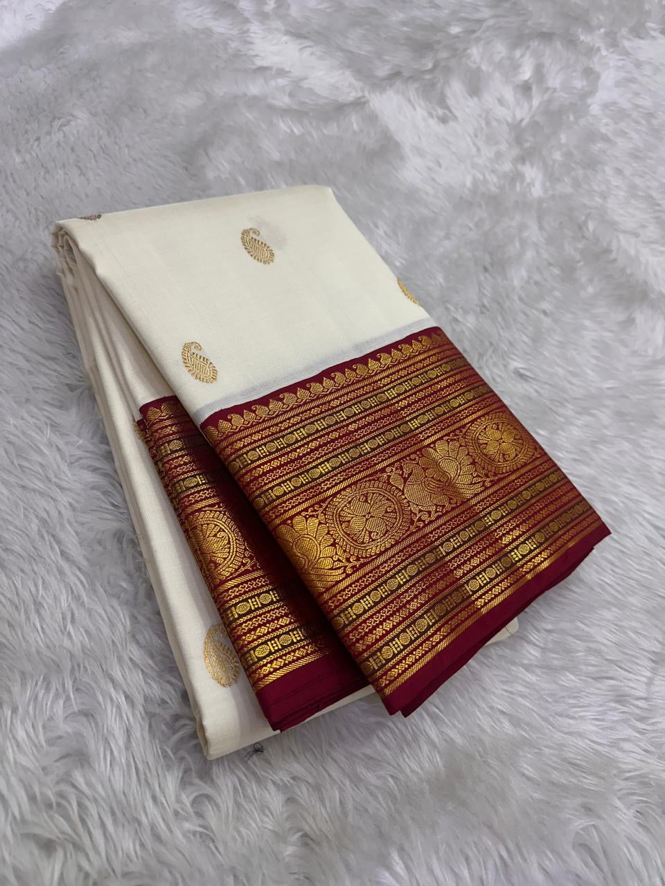 Ivory handwoven Kanchipuram Varisaipet silk saree with Arakku red border and gold zari.