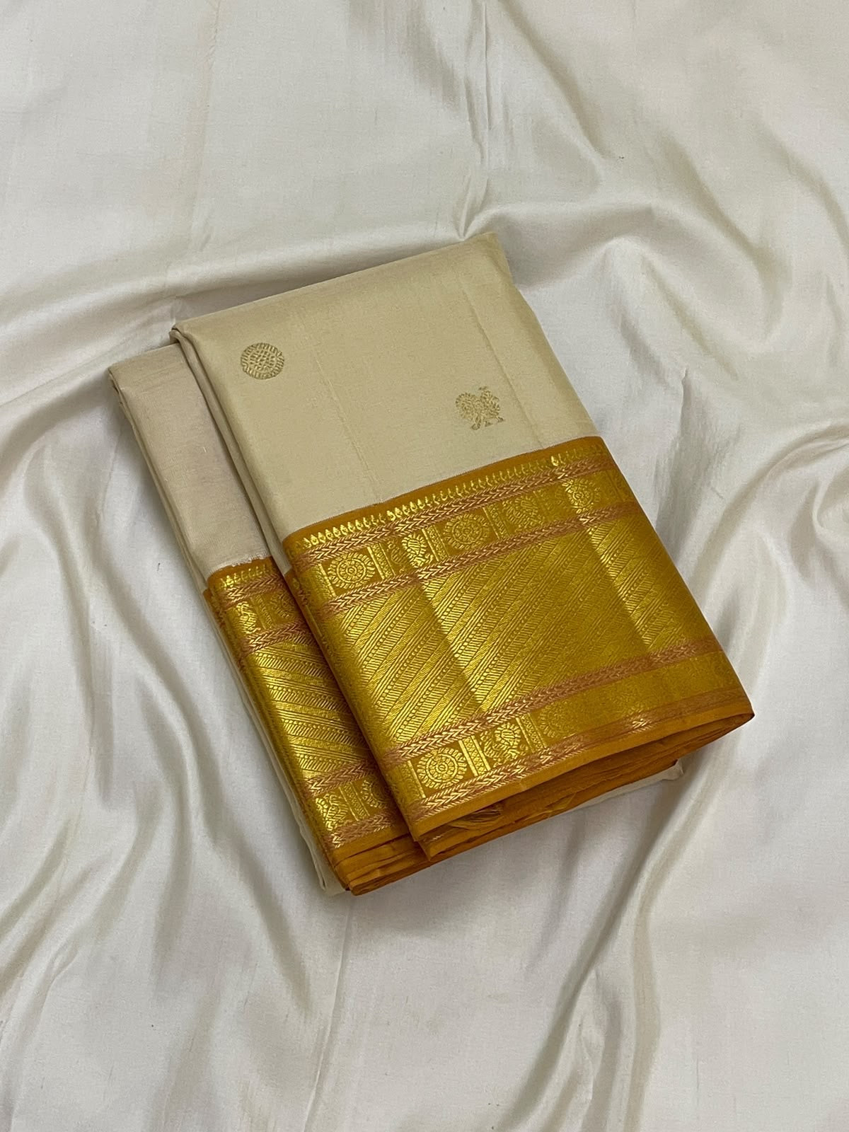Warm Ivory Handwoven Pure Silk Kanchipuram Saree with Bavanji Border and Mayil Chakram, folded saree presentation