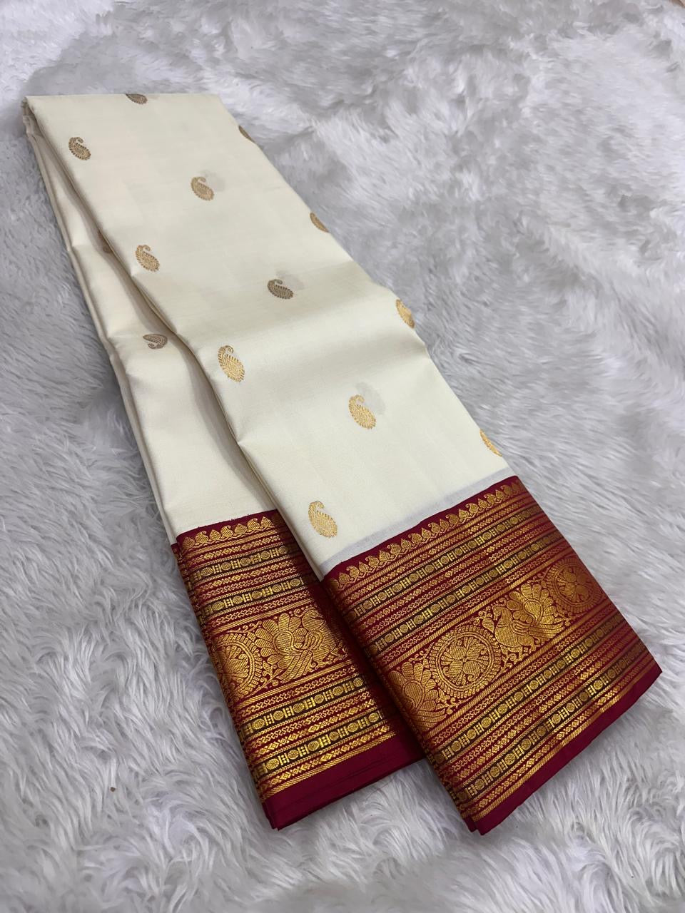 Ivory Kanjivaram silk with a deep Arakku red Varisaipet border in layered zari registers.