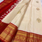 Ivory pure silk body showing spaced floral zari buttas and subtle green Meenakari accents.
