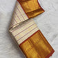 Kamalam lotus and Mayil peacock buttas in gold zari, warm-ivory Kanjipuram saree