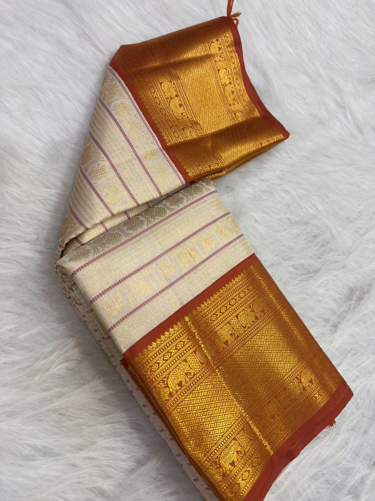 Kamalam lotus and Mayil peacock buttas in gold zari, warm-ivory Kanjipuram saree