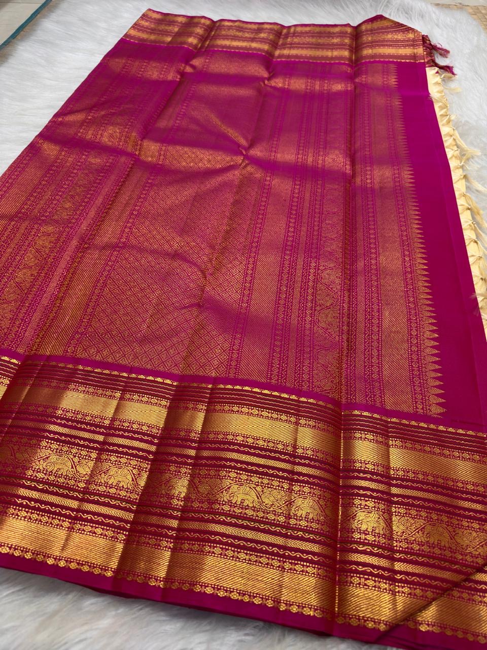 Ivory and magenta pink Kanchipuram silk saree draped to show body and border