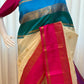 Full drape with hot pink border and teal-blue pallu accents displayed indoors, shipped from New Jersey USA.