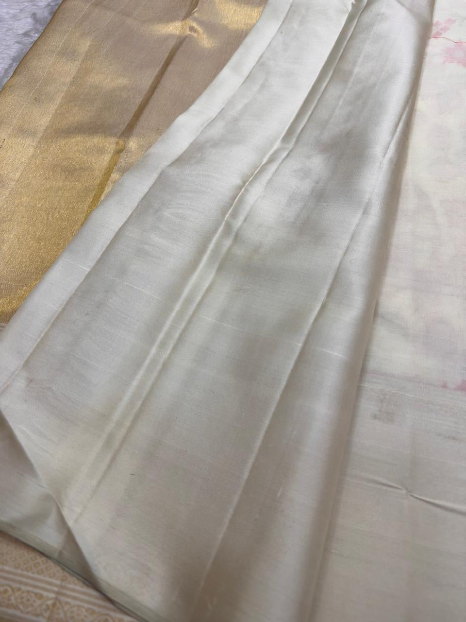 Close view of pale antique-gold geometric zari border on Pearl Ivory Kanchipuram silk.