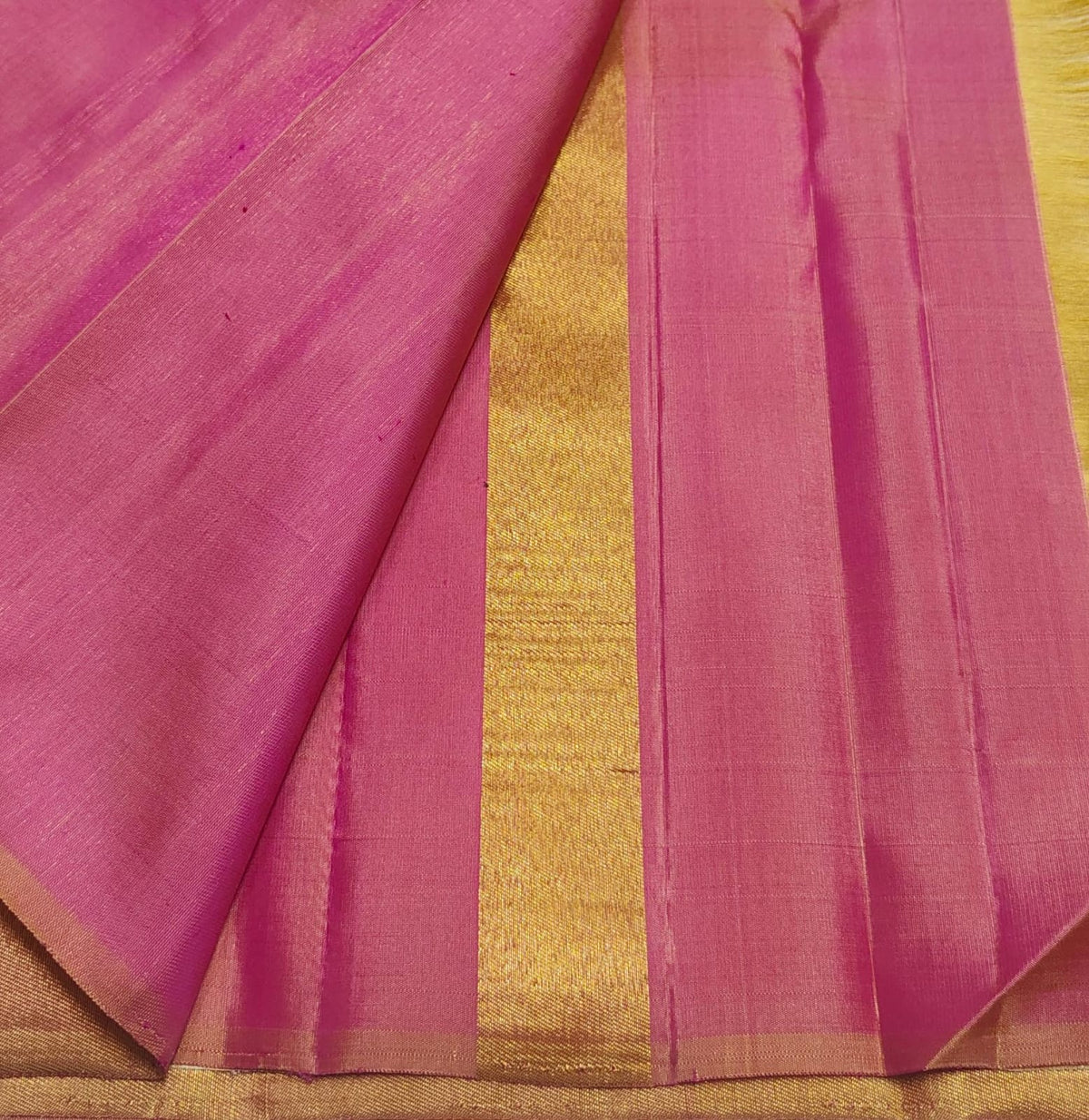 Close view of Rani Pink triangular temple edge against Warm Ivory Kanjivaram silk.
