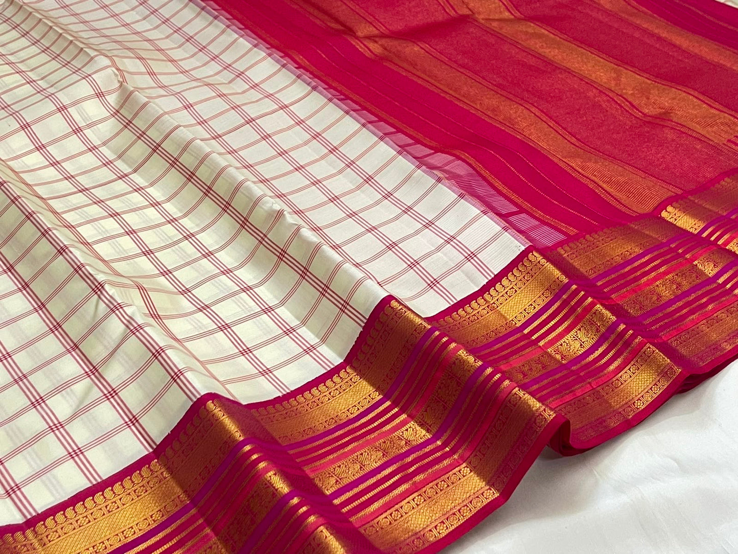 Ivory raspberry pink handwoven pure silk Kanchipuram saree with gold zari border, folded view