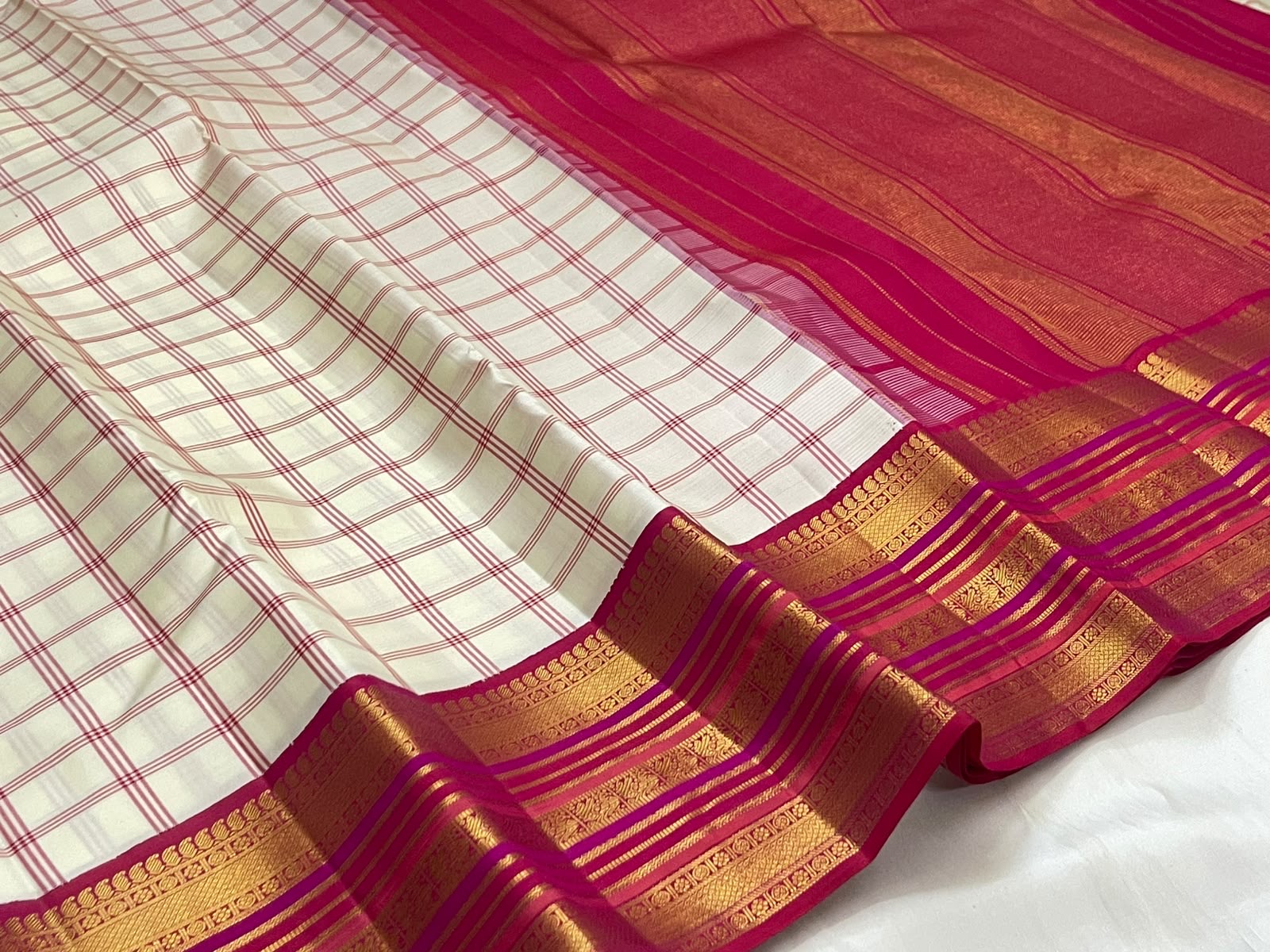 Ivory raspberry pink handwoven pure silk Kanchipuram saree with gold zari border, folded view