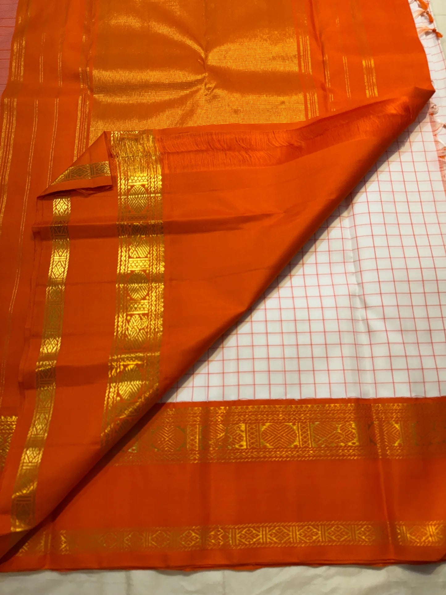 Ivory Kanchi Pattu saree body close-up showing fine rust orange check weave