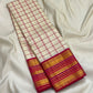 Ivory white Kanchipuram saree with raspberry pink border, close-up