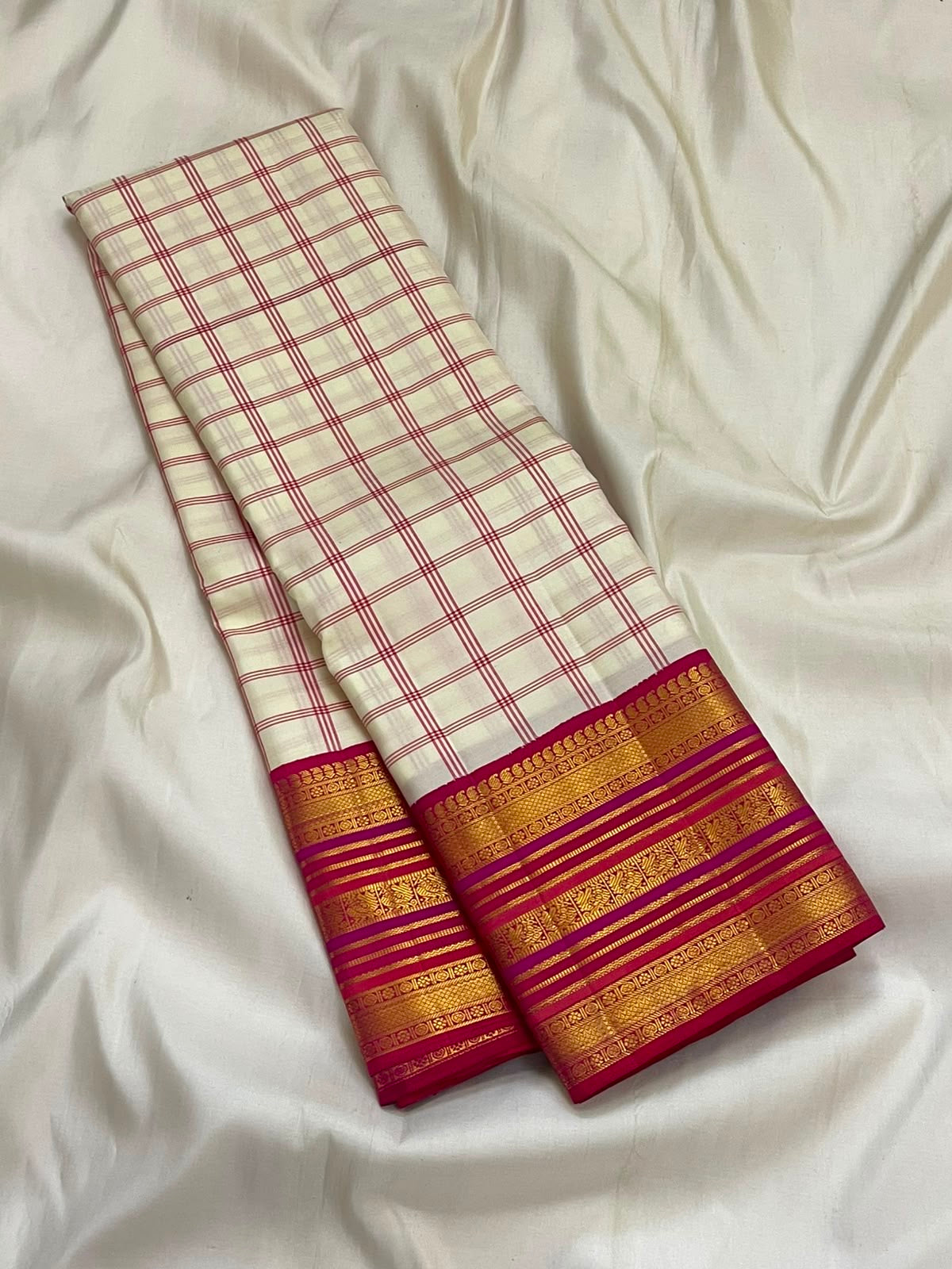 Ivory white Kanchipuram saree with raspberry pink border, close-up