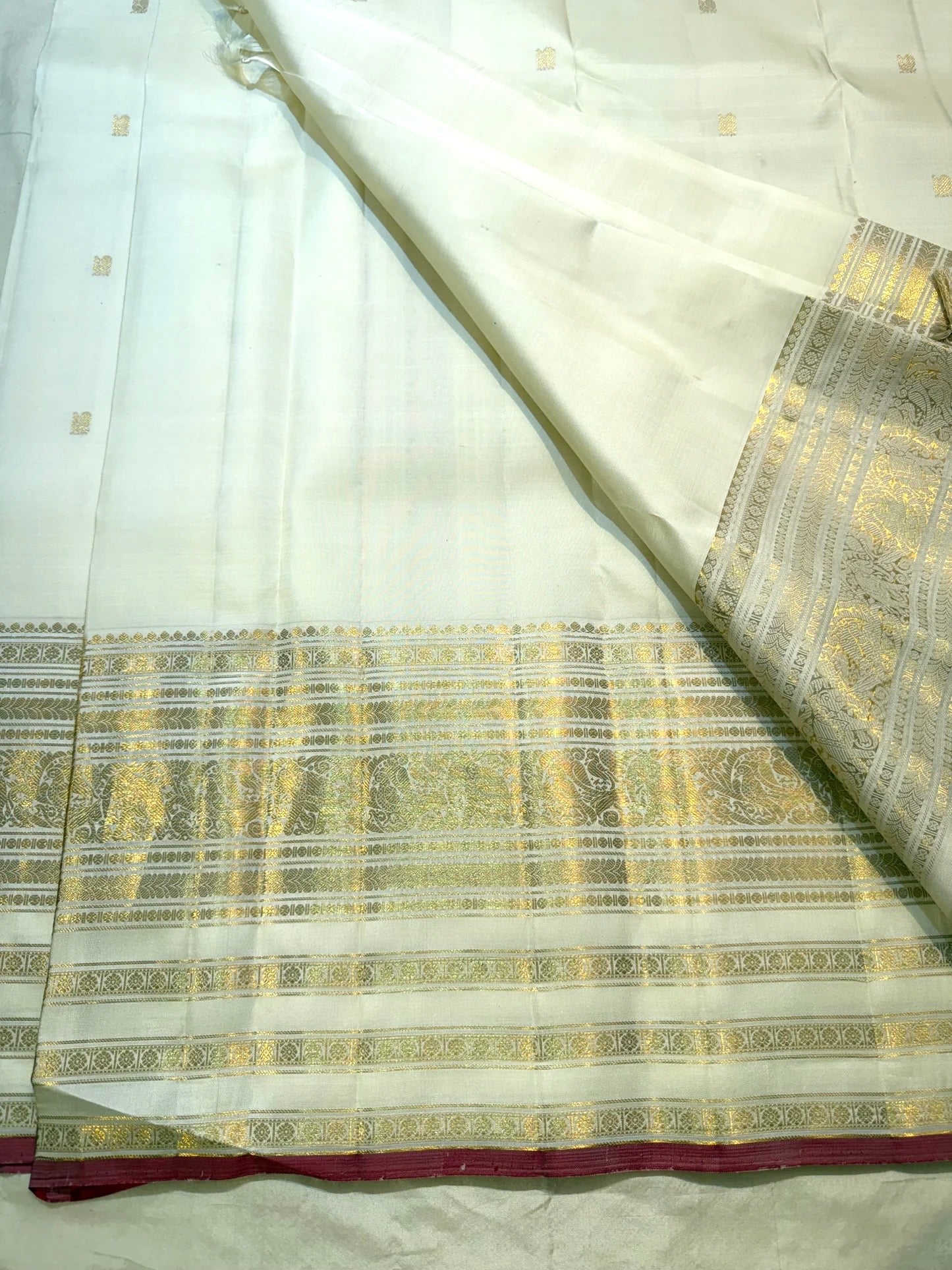 Close-up of raspberry pink selvedge edge on ivory pure silk Kanchipuram Butta saree