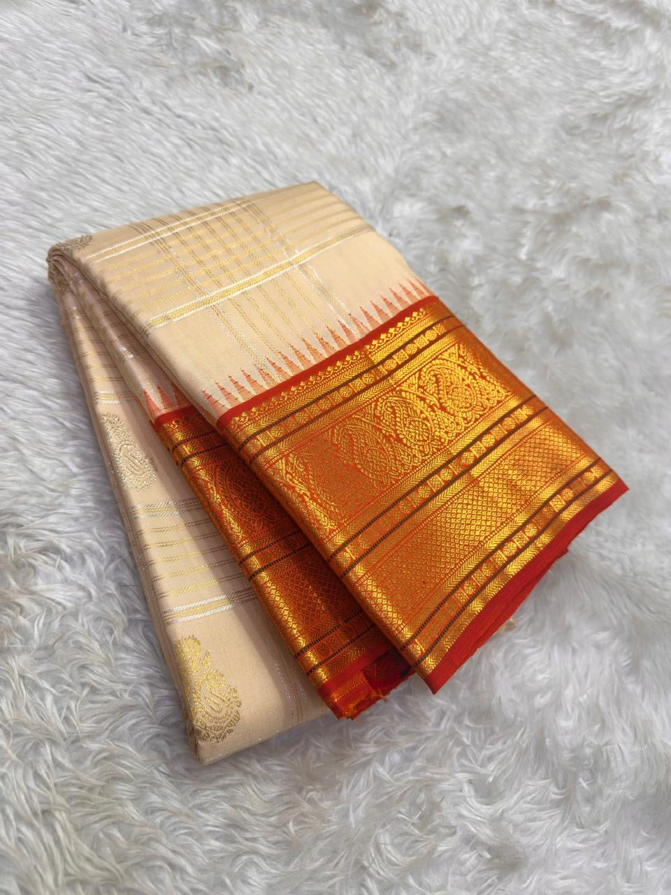 Korvai border with Paisley motifs in gold zari on deep red ground of ivory Kancheepuram saree