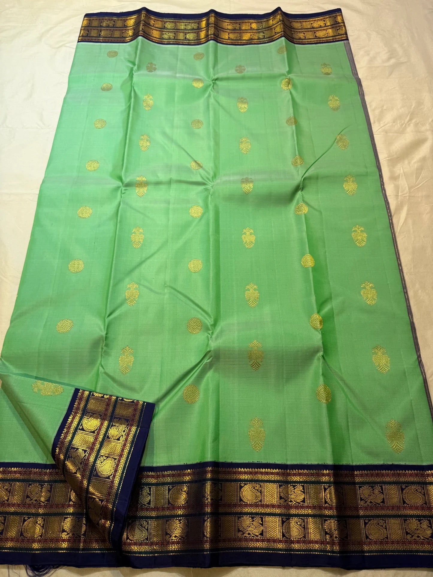 Deep navy korvai border with ornate gold zari peacock pallu panels on jade green saree — Idam Living