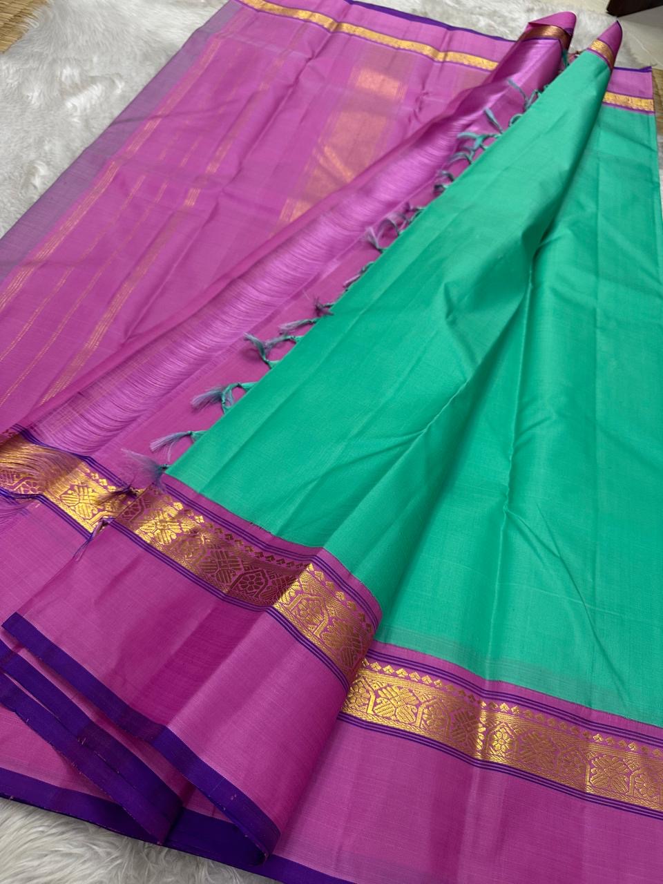 Kanchipattu silk saree in jade green with lily pink border Korvai Kaal Irangiya Border weave traditional zari detail