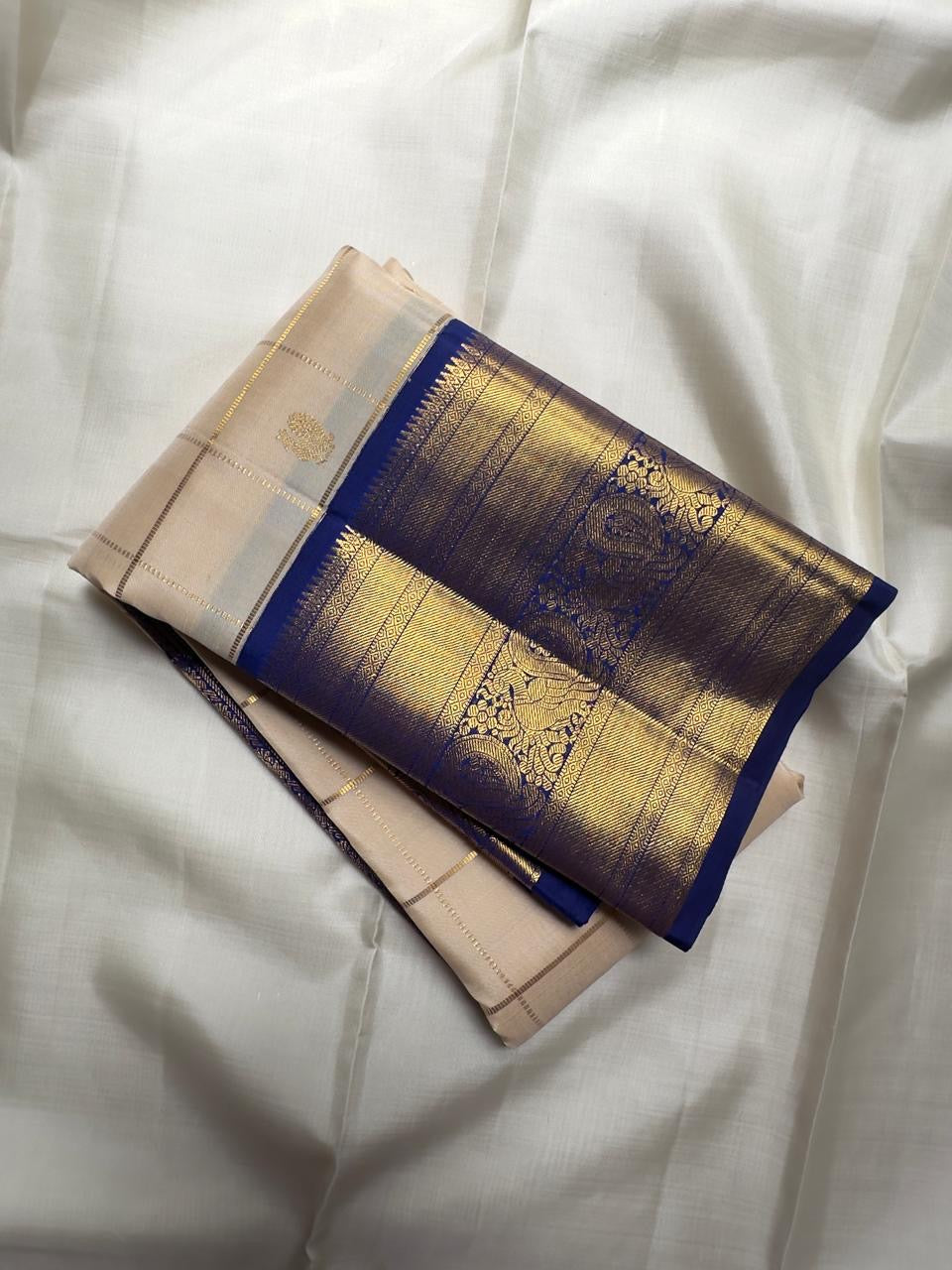 Jasmine Ivory Kanchipuram saree contrasted with temple-indigo blue, gold zari panels and Reku detailing.