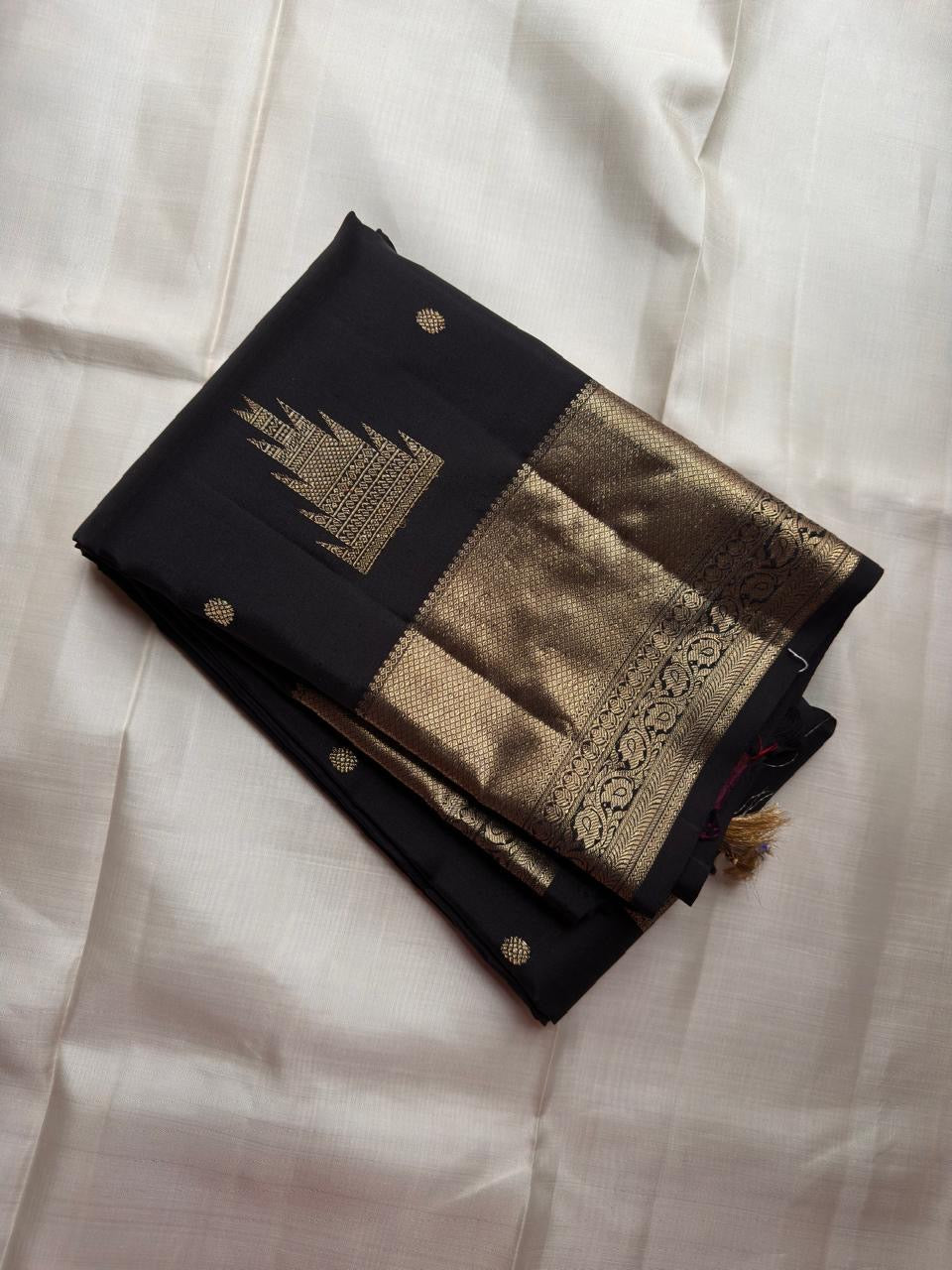 Black pure silk Kanjivaram Butta saree with broad antique-gold zari border.