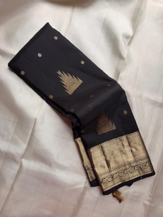 Jet Black pure silk Kanjivaram Butta saree with traditional Thazhampoo Reku zari motifs.