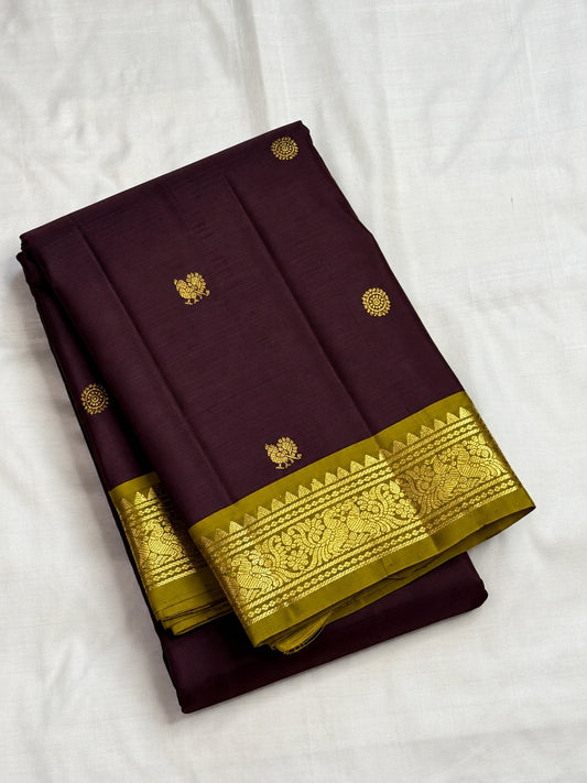 Kaapi Brown silk saree with repeated Mayil Chakram gold buttas and slim Mehendi Green and gold zari border