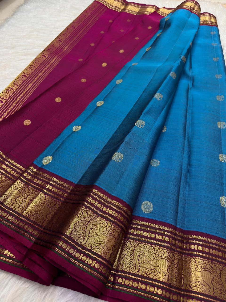 Deep Arakku-maroon Kanchipuram border with intricate classic-gold floral zari and ornamental bands.