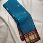 Kadal Neelam teal-blue Pure Silk Kanchipuram Butta saree with traditional gold buttas and Arakku border.