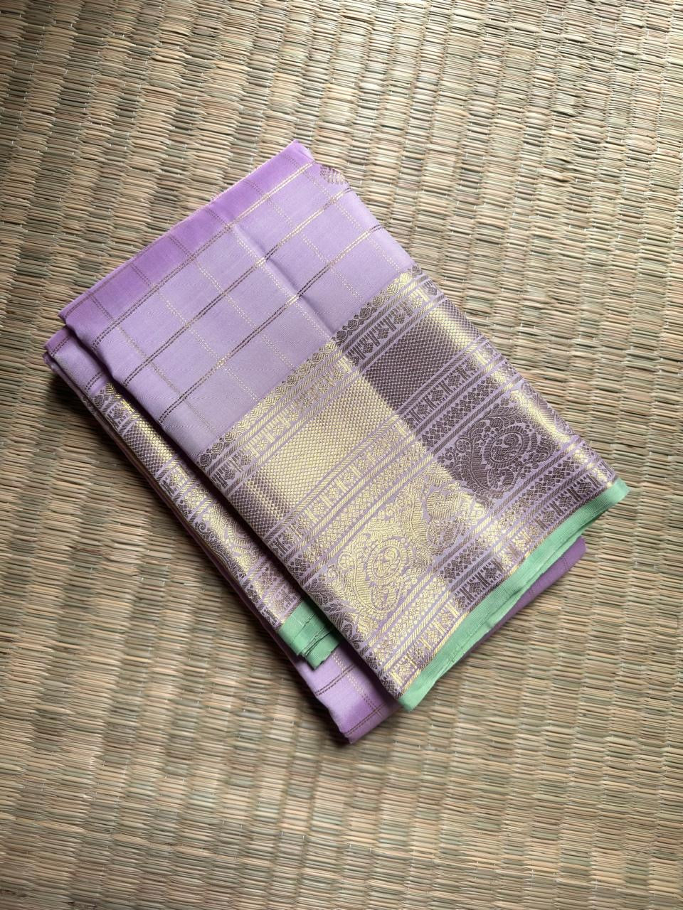 Pale Pink Lavender-undertone Zari Kattam body showing Kamalam buttas and richly woven Peacock border.
