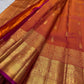 Coral-toned Kanakambaram Kanjeevaram silk with petite zari buttas and traditional Chakram border work
