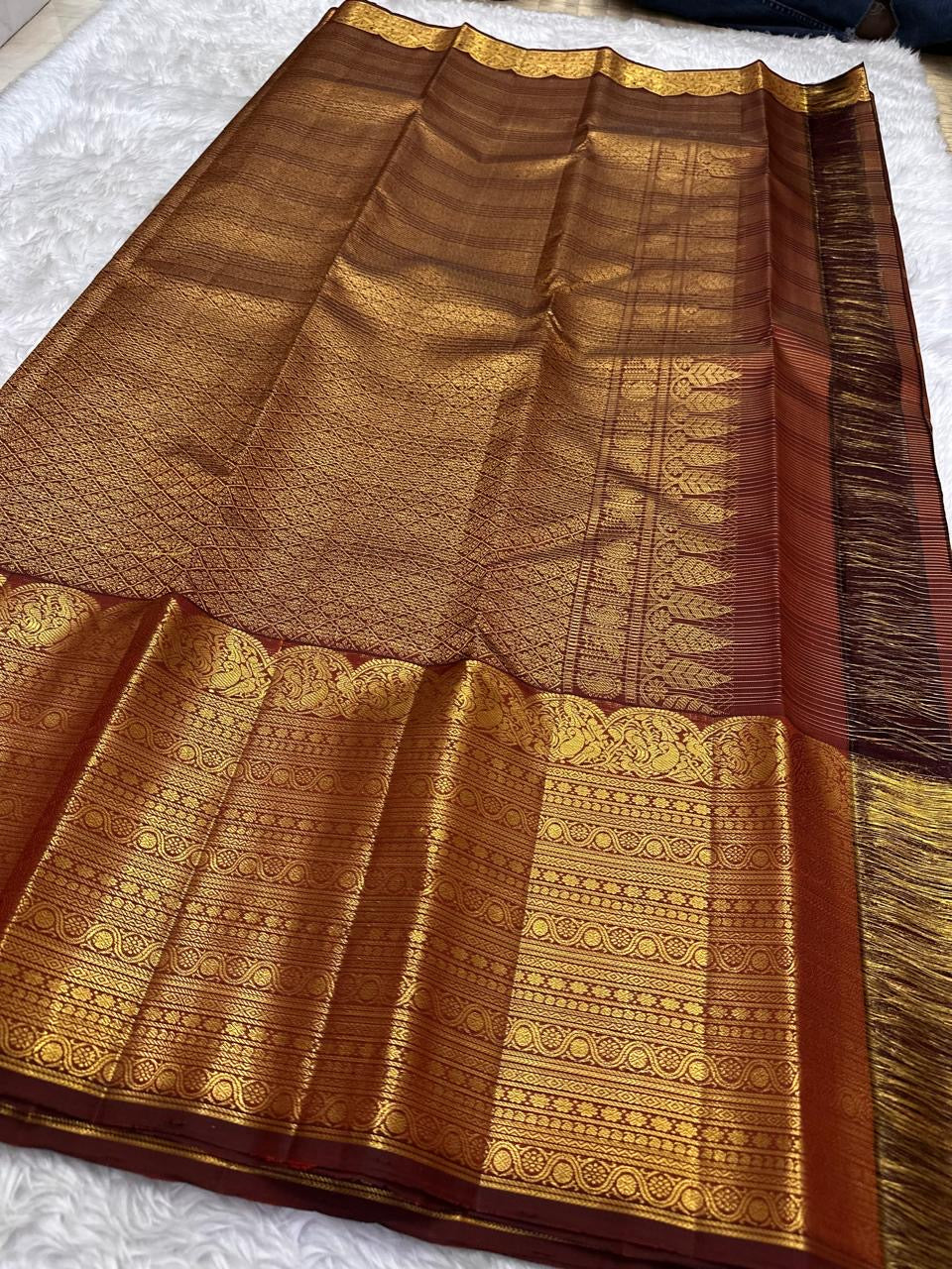 Maanga-style curved classic-gold zari ornament along the traditional Cinnamon Brown border.