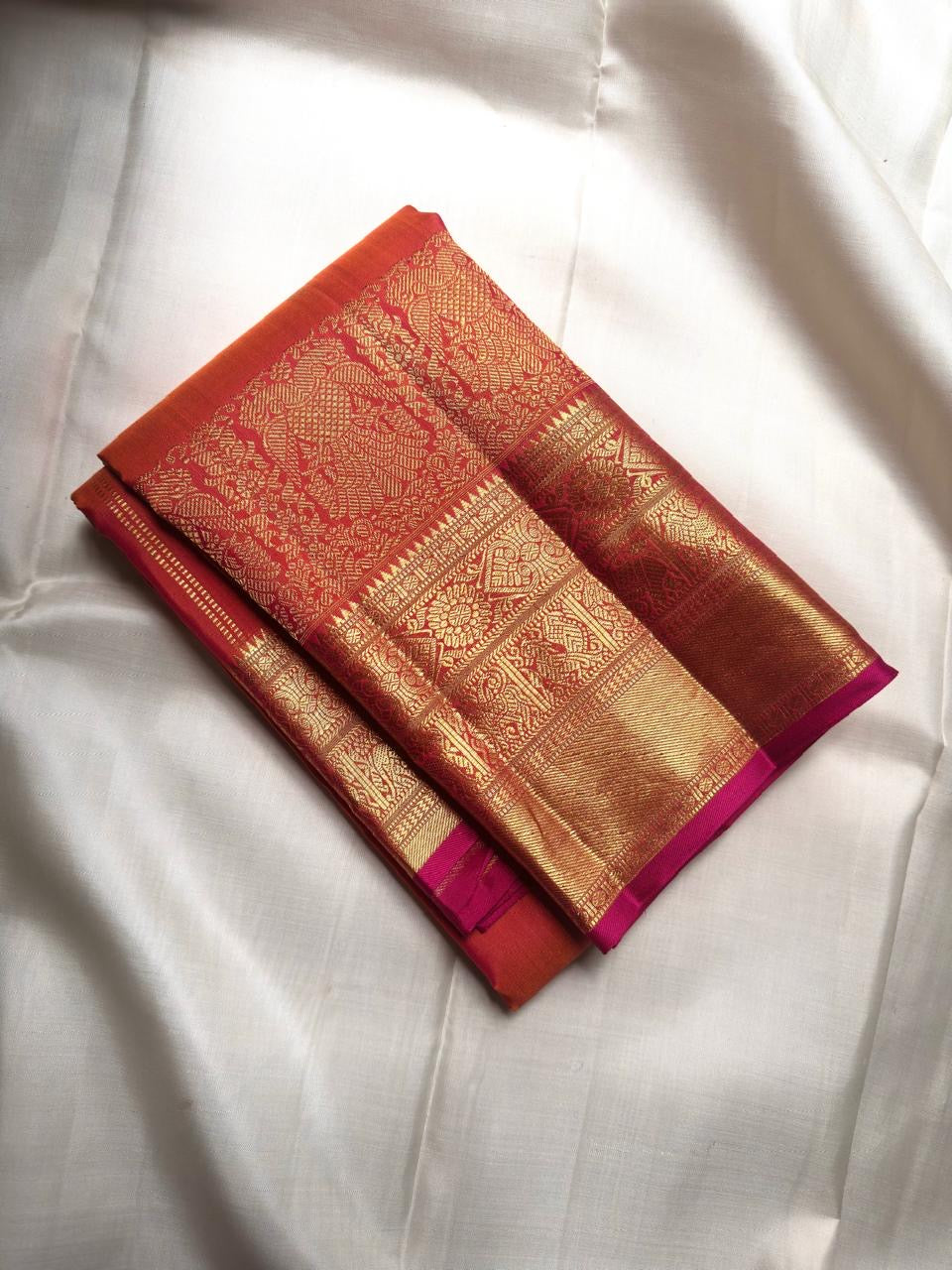 Kanakambaram orange Pure Silk Kanchipuram saree with Maanga buttas and broad Mayil gold zari Pettu