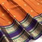 Kanakambaram orange handwoven silk body with neat chakra-pushpam zari buttas and soft natural lustre.