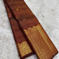 Broad classic-gold ornamental registers framing the earthy cinnamon-brown Kanchipuram body.