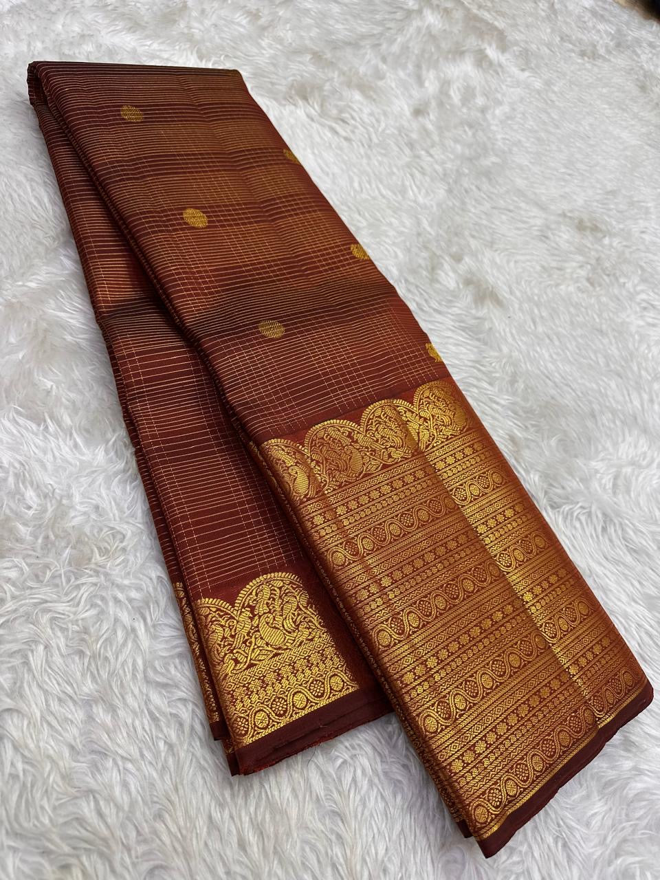 Broad classic-gold ornamental registers framing the earthy cinnamon-brown Kanchipuram body.