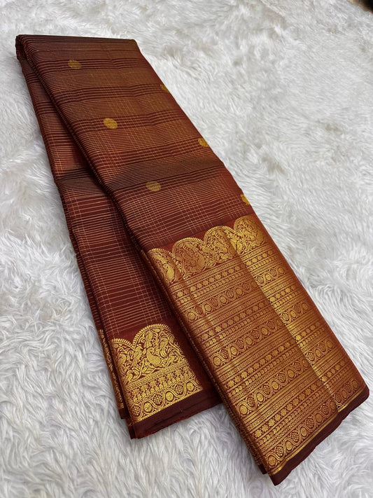 Broad classic-gold ornamental registers framing the earthy cinnamon-brown Kanchipuram body.