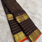 Close view of antique-gold traditional zari motifs woven on deep brown Kanjivaram silk.