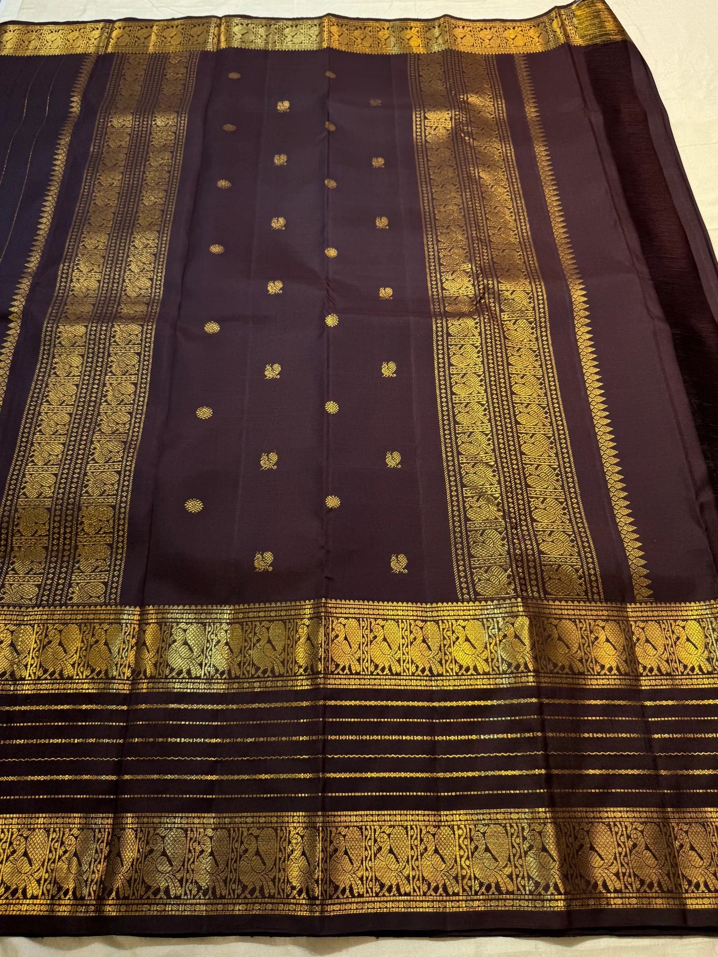 Close view of luminous gold zari buttas across Deep Kanchana Brown pure mulberry silk.