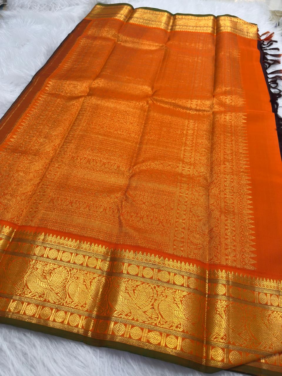 Orange Kanchipuram border with large repeating Mayil figures woven in gold zari.