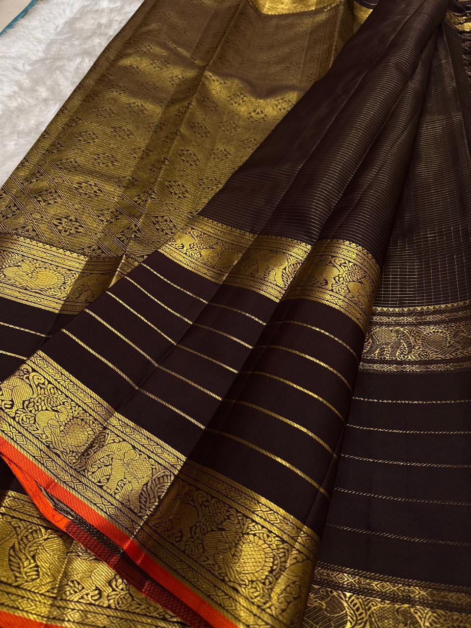 Dark brown Kanchipuram silk saree with fine gold checks and spaced zari motifs.