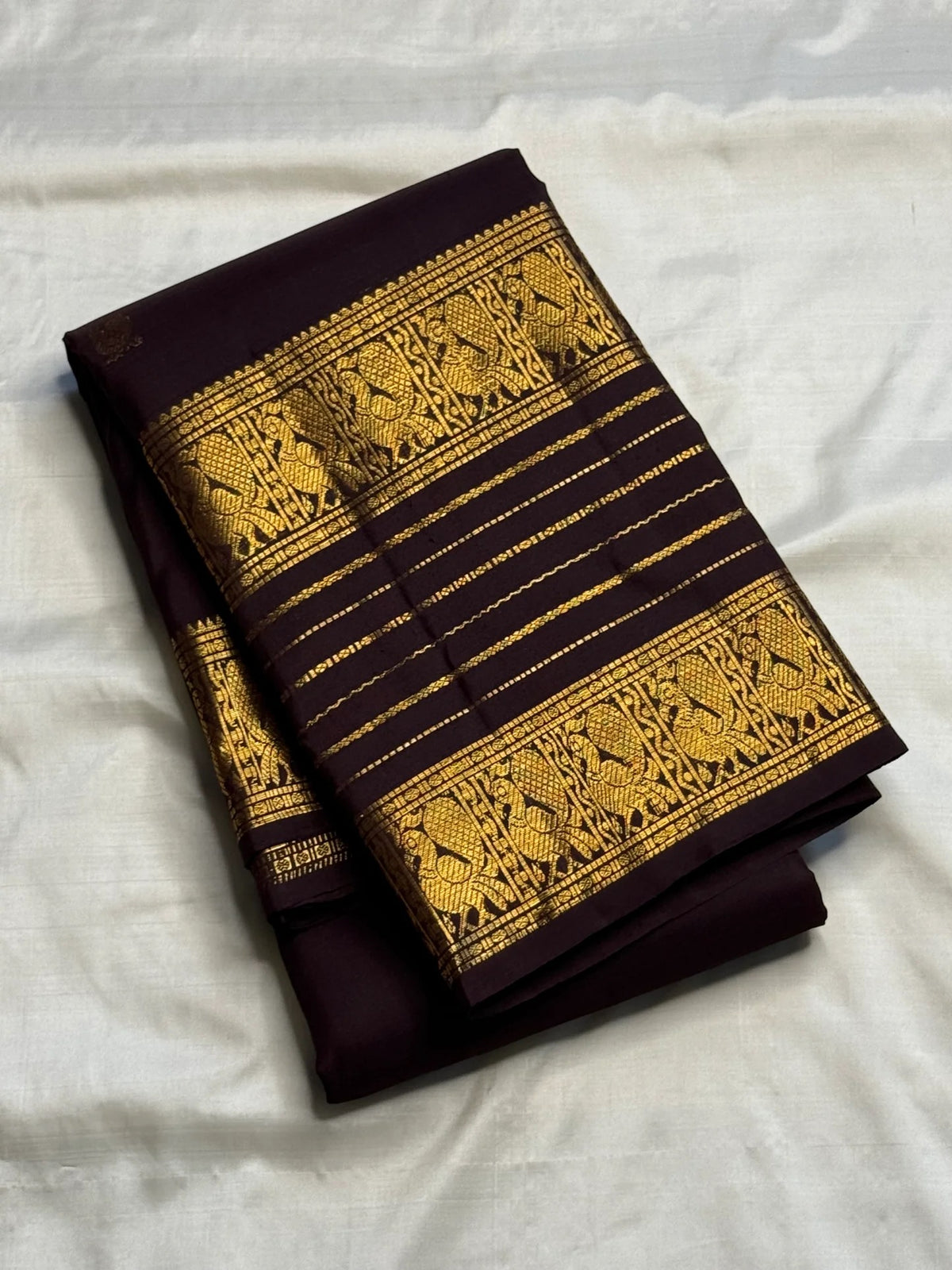 Close view of antique-gold traditional bird motifs woven across Deep Kanchana Brown Varisaipet border.