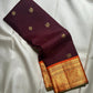 Deep Kanchana Brown silk body with individually woven gold zari Mayil and circular buttas.
