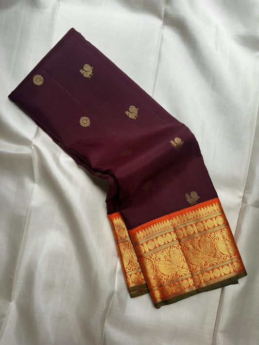 Deep Kanchana Brown silk body with individually woven gold zari Mayil and circular buttas.
