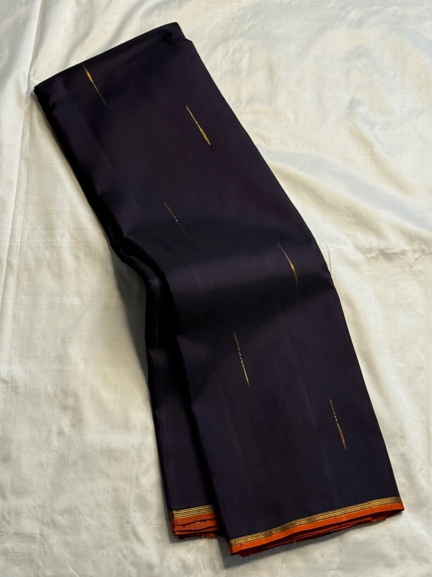 Kanchana Brownish Purple pure silk Kanjivaram Butta saree with minimal orange border.